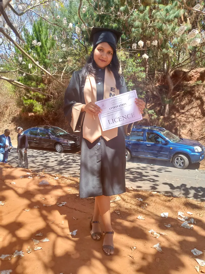 Niriantsoa en toge et toque, tenant son attestation de Licence de l'École Normale Supérieure