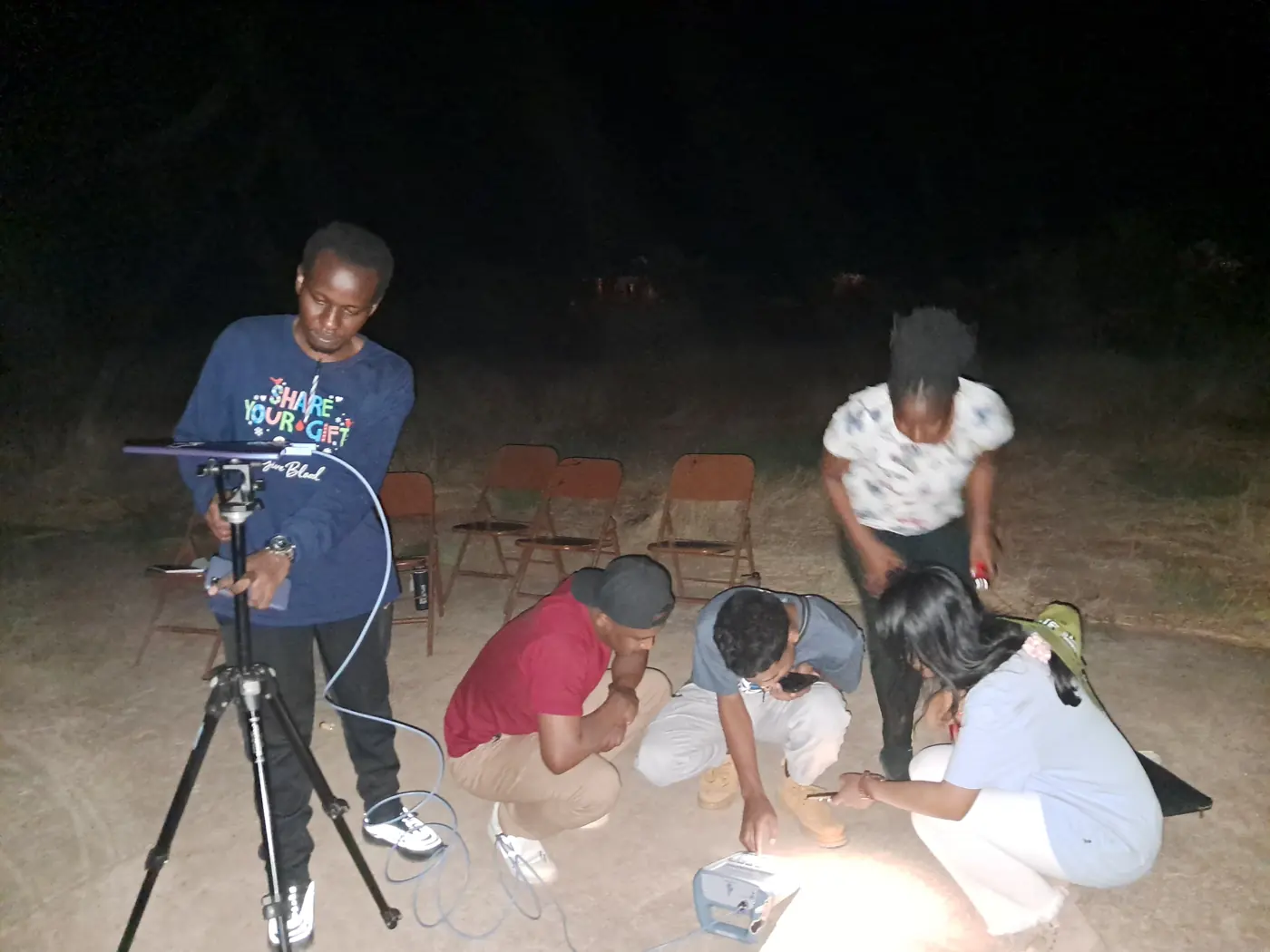 De nuit, un groupe de stagiaires DARA autour d'une antenne sur trépied reliée à un appareil de mesure posé au sol
