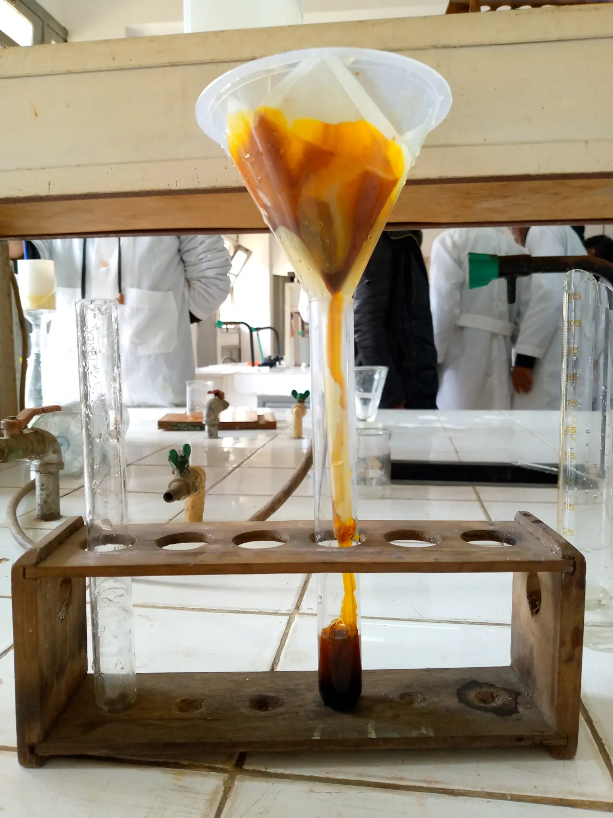 Filtration : entonnoir garni d'un filtre orange au-dessus d'un tube à essai